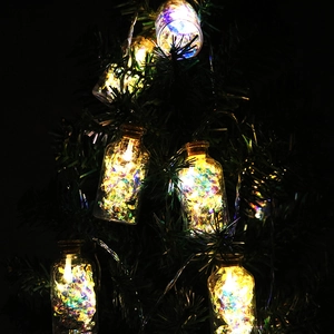 Christmas LED bottle string lights with colorful sequins hanging on a festive Xmas tree