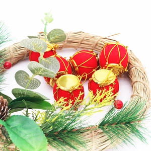 Detail of red flocked Christmas drum ornaments with gold strings on a festive wreath