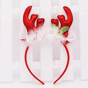 Detail of red Christmas antler headband with white fur trim and festive holly decorations