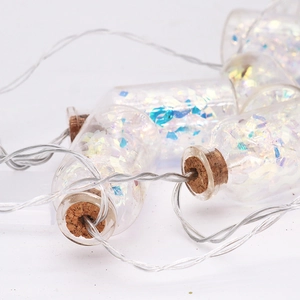 Close-up of LED glass jar fairy lights with cork stoppers and glitter sequins