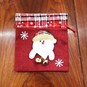 Detail of Christmas burlap gift bag featuring a 3D Santa Claus and golden bells