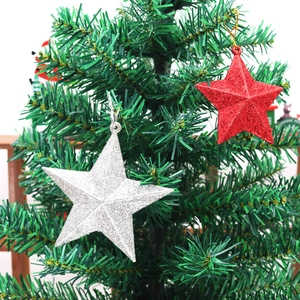 Detail of red and silver glittery star ornaments hanging on a green Christmas tree