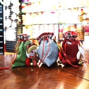 Three festive Christmas drawstring burlap gift bags with Santa, reindeer, and snowman dolls