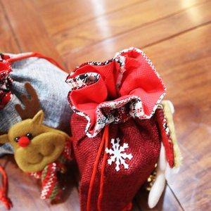 Detail of Christmas burlap gift bags with red snowflake and gray reindeer designs
