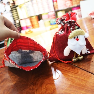 Detail of Christmas burlap gift bag with Santa Claus applique and golden bell charm