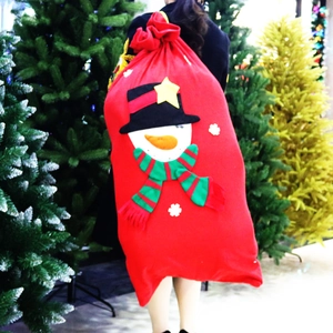 Extra large red Christmas snowman drawstring gift bag carried on a person back for scale