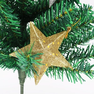 Détail macro d'une étoile dorée pailletée avec cordon sur branche de sapin de Noël vert