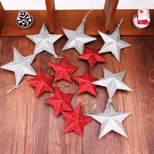 Close-up of sparkling red and silver glitter star ornaments on a wooden surface