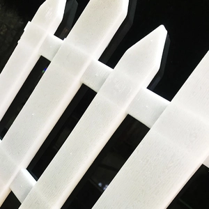 Close-up of white garden fence panel with wood grain texture and pointed tops