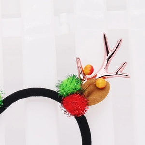 Detail von Weihnachts-Stirnband mit roségoldenen Geweihen und bunten Plüschkugeln