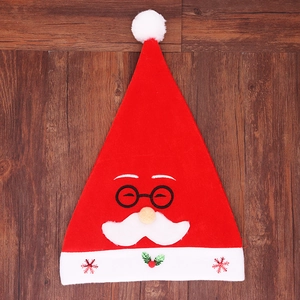 Dettaglio del cappello di Natale rosso con ricamo di Babbo Natale e fiocchi di paillettes