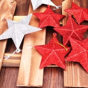 Close-up of red and silver glittery star ornaments on a dark wooden background