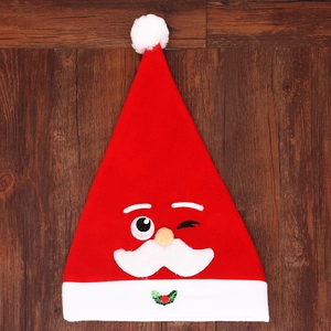 Dettaglio cappello natalizio rosso con ricamo di Babbo Natale e pon pon bianco