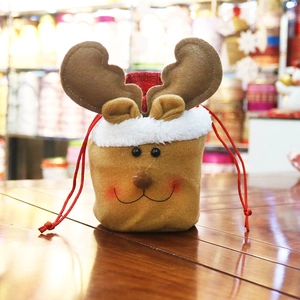 Christmas reindeer drawstring gift bag made of soft plush fabric on a wooden background