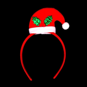 Detail of red Christmas hat headband with green holly leaves on black background