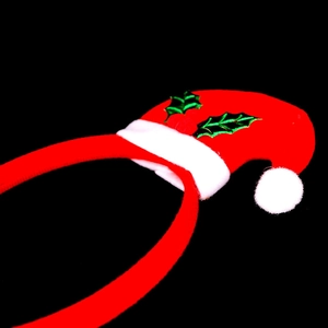 Detail of Christmas headband featuring a mini red Santa hat with holly leaves and berries