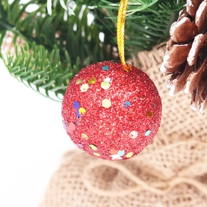 Sparkling red glitter Christmas tree ornament balls with gold string on festive branches