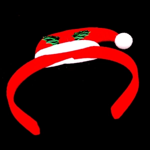 Detail shot of a festive Christmas mini hat headband with holly leaf on black background