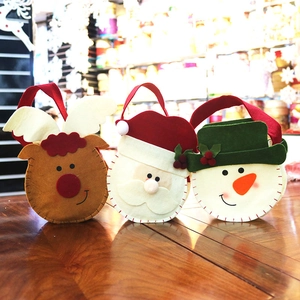 Detail of three handmade felt Christmas gift bags with Santa, reindeer and snowman designs
