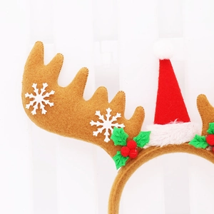 Detail of Christmas reindeer antler headband with mini Santa hat and holly berry accents