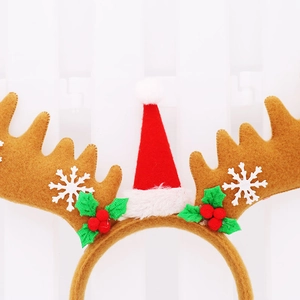 Detail of Christmas headband with reindeer antlers, mini Santa hat and holly leaves decoration