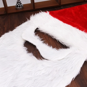 Gros plan d'une barbe en fausse fourrure blanche et d'un bonnet de Noël rouge peluche