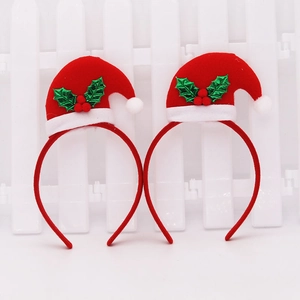 Detail of red Christmas hat headbands with velvet fabric, holly leaves and white fur trim