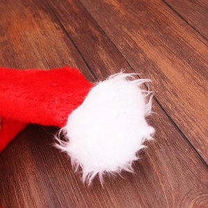 Détail du tissu en peluche rouge doux et du pompon blanc moelleux du bonnet de Noël