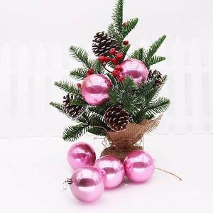 Close-up of pink pearlescent Christmas ball ornament hanging on a festive decorated tree