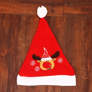 Classic red Christmas hat with embroidered reindeer and snowflakes on dark wood background