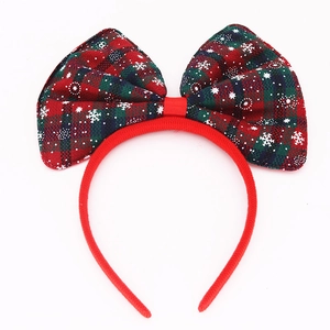 Christmas headband with red and green plaid bow featuring white snowflake patterns