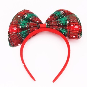 Christmas headband with large red and green plaid bow featuring snowflake prints