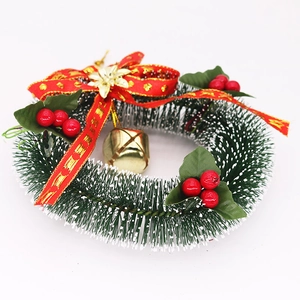Detail of 15cm Christmas wreath with red bow, golden bells, and snow-tipped pine needles