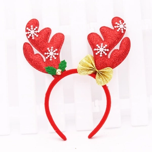Red Christmas reindeer antler headband with gold glitter bow and small bell on white fence