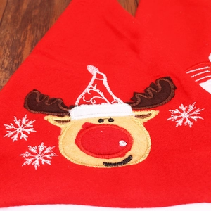 Festive red felt Christmas hat with exquisite reindeer embroidery on wooden background
