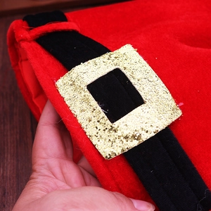 Detail of red plush Christmas hat with a black velvet belt and shiny gold sequin buckle