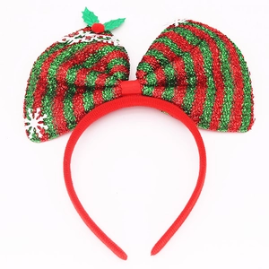 Detail of Christmas headband featuring glittery red and green bow with Merry Christmas text