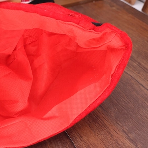 Detailed macro view of red plush Christmas hat interior showing lining and seams