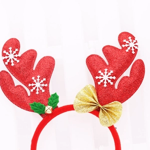 Detail of reindeer antlers headband with red glitter, gold bows and holly leaves