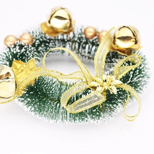 Close-up of 15cm Christmas candle ring with green pine needles, gold bells and ribbon bow