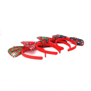 Detail view of four Christmas bow headbands with red green plaid and sequins on white background