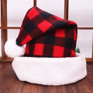 Classic red and black buffalo plaid Christmas hat with plush white trim on wooden background