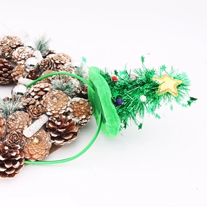 Serre-tête de Noël avec sapin vert, étoile dorée et pommes de pin sur fond blanc pur
