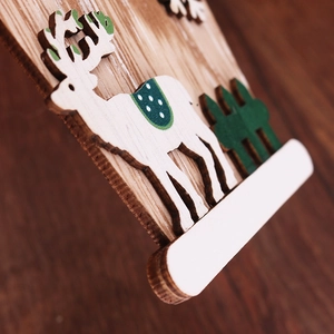 Makro-Detail des mehrschichtigen 3D-Rentier-Weihnachtsschmucks aus Holz mit Tannenbaum