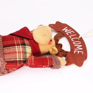 Detail of Christmas reindeer plush doll holding a Welcome sign with red plaid fabric