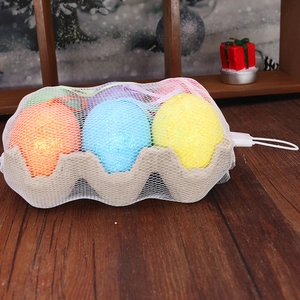 Œufs de Pâques à paillettes colorés avec sac en filet et plateau sur bois