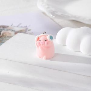 Cute pink flocked pig pendant with white headphones on a white decorative display stand