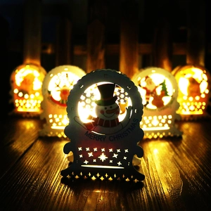 Close-up of white wooden LED Christmas house ornament with warm light and snowman carving