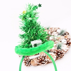 Detail of LED Christmas tree headband with green sequins and a white power switch