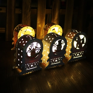 Detail of wooden Christmas lanterns with warm LED lights and carved Santa motifs